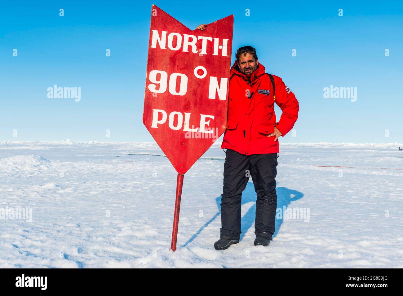 Mann posiert mit einem Nordpol-Schild am Nordpol, Arktis Stockfoto
