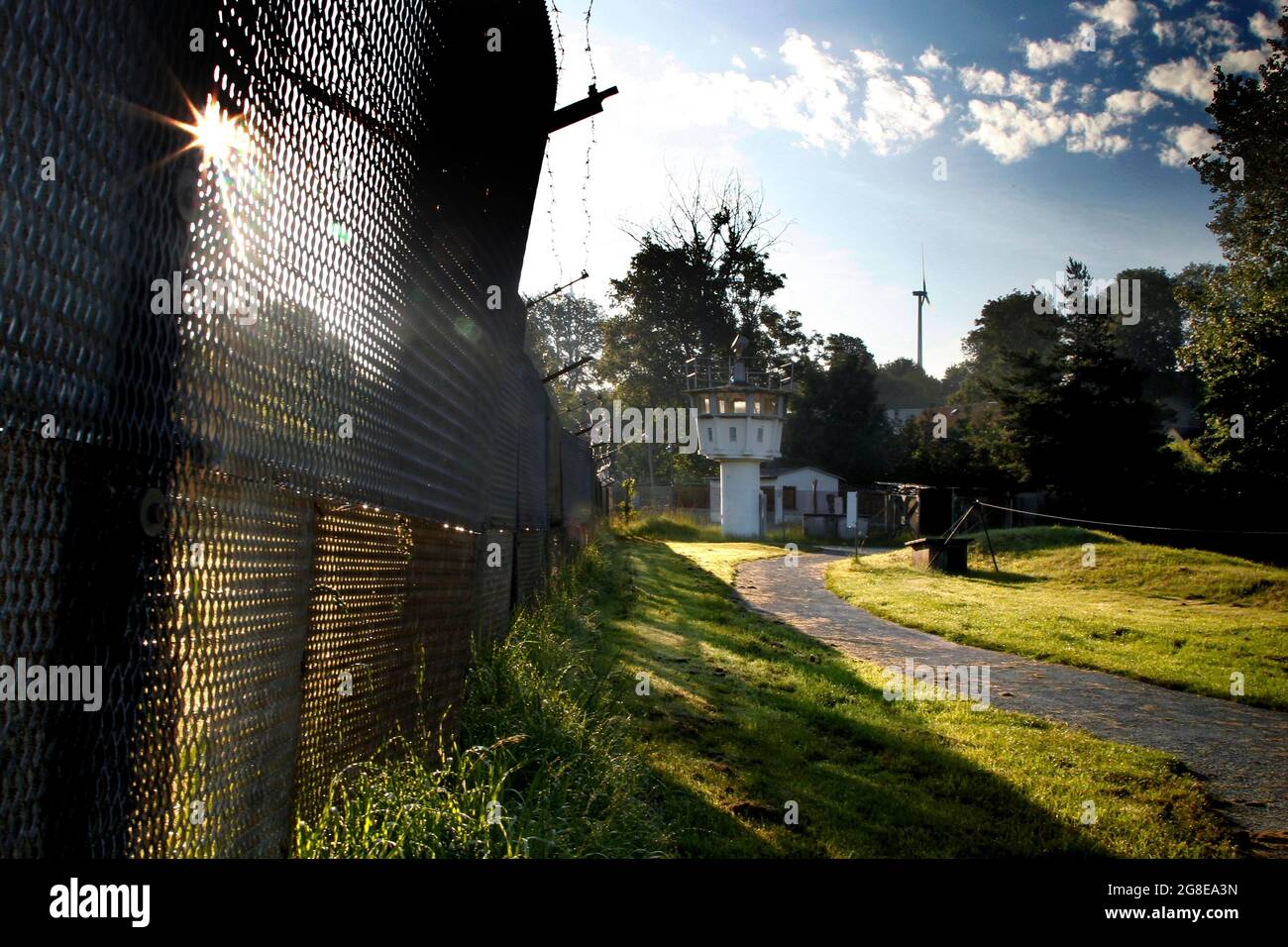 Grenzzaun, erweiterter Metallzaun, Grenzsignalzaun, Stacheldrahtzaun, Hintergrundbeleuchtung, sonnenaufgang, Aussichtsturm der Grenztruppen der DDR Stockfoto