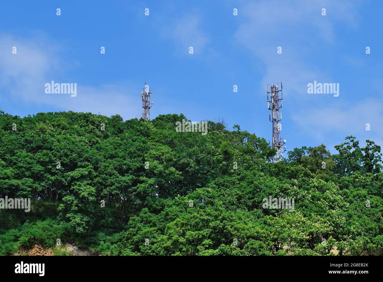 Antennentürme von 3g, 4g, 5g Mobilfunk, in einem Waldgebiet auf einem Hügel in einem ländlichen Gebiet. Die Verbreitung moderner Technologien in spärlich popat Stockfoto