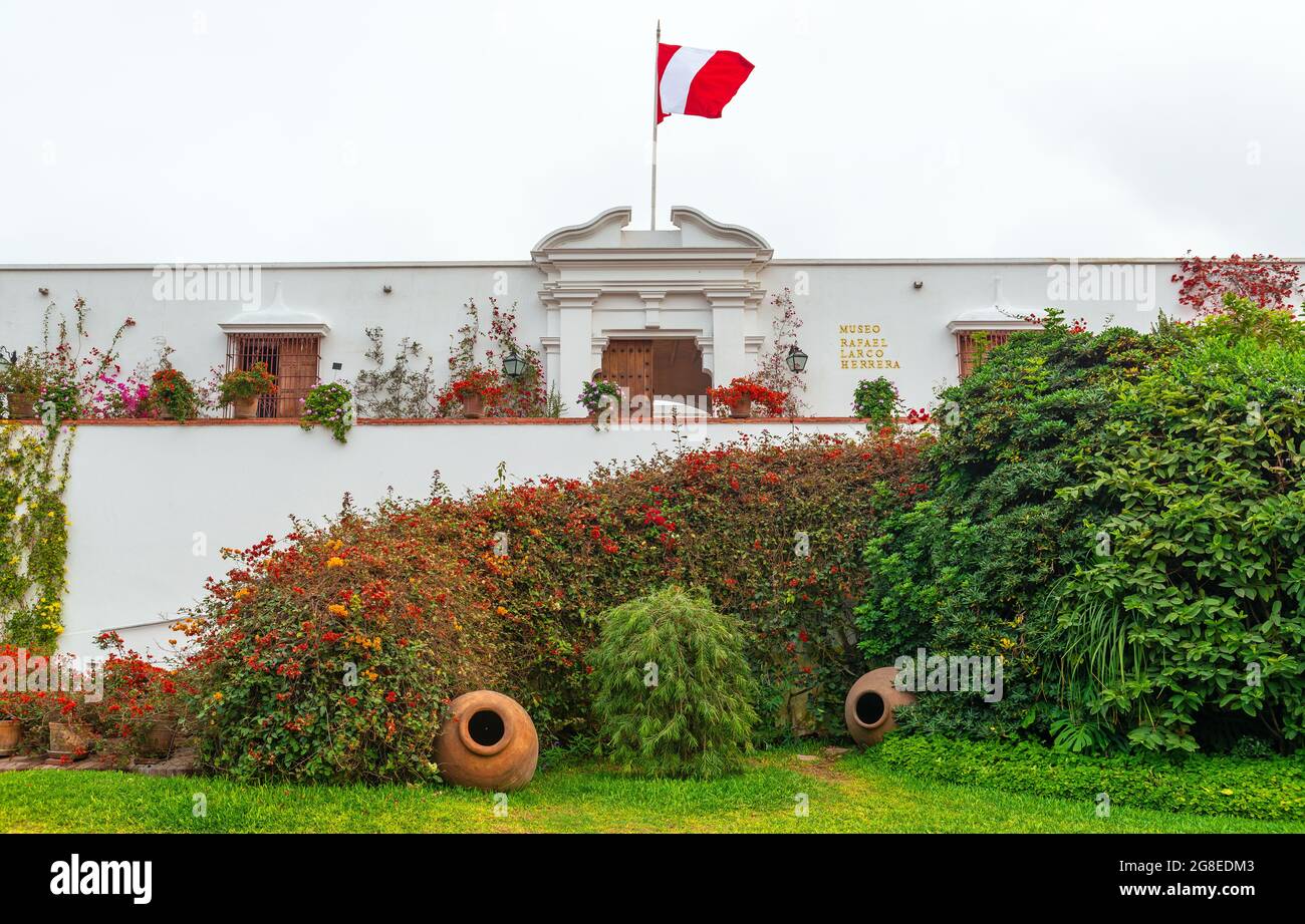 Eingangsfassade und Tür des Archäologiemuseums Larco Herrera mit Garten und peruanischer Flagge, Lima, Peru. Stockfoto