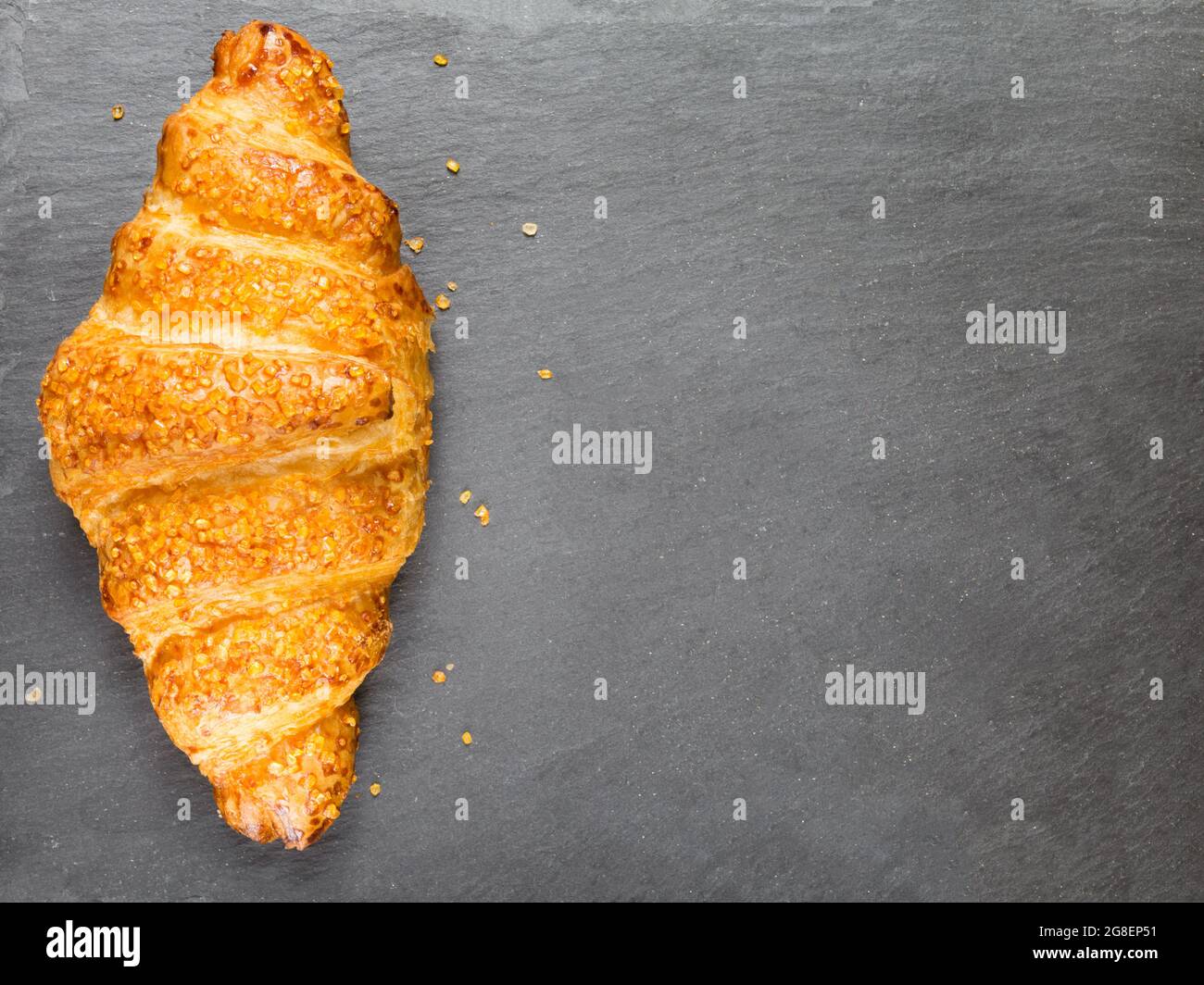 Leckeres Croissant auf schwarzem Stein Hintergrund. Französisches Essen. Speicherplatz kopieren. Low-Taste Stockfoto