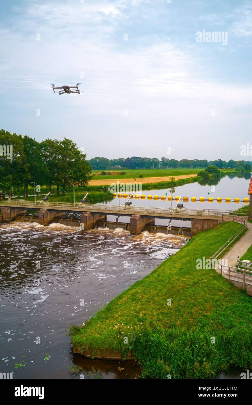 Eine Luftaufnahme mit Drohne im Hintergrund über einem Wehr im Fluss Vecht in den Niederlanden. Flussabwärts befindet sich Sluiswachtershuis neben der Brücke. Fisch Stockfoto