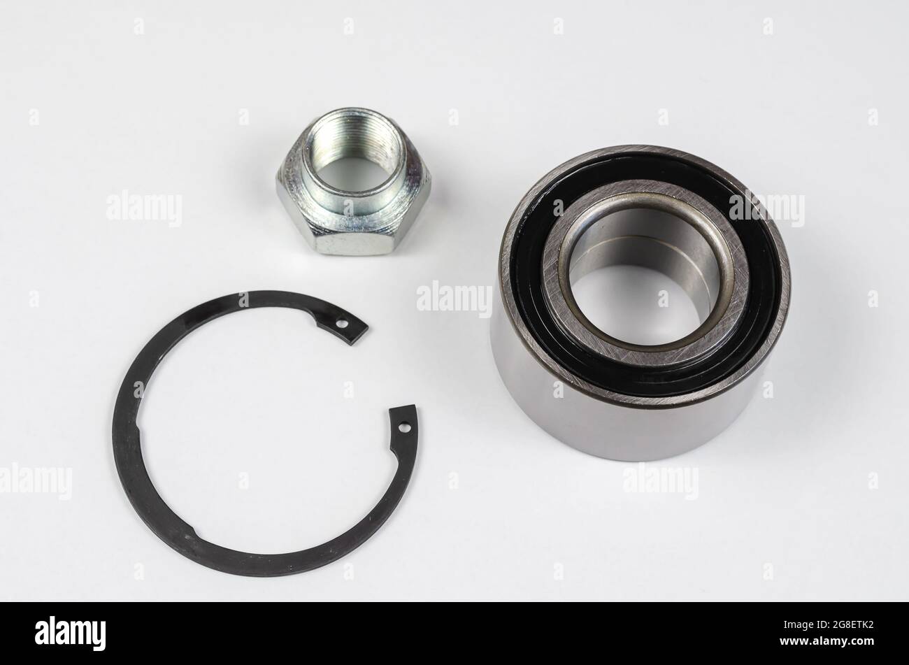 Satz von Autoteilen auf weißem Hintergrund. Neuer Sicherungsring, Sondermutter und Nabenlager. Ersatzteile, Verbrauchsmaterialien. Stockfoto