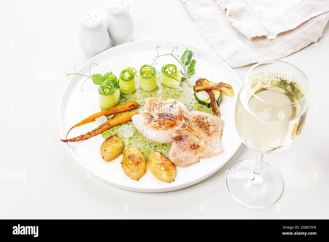 Nahaufnahme gegrillter Tintenfisch mit Gemüse. Tintenfisch mit Babykartoffeln, Zucchini, frischem Gemüse der Saison und Kräutersauce. Mediterrane Küche. Stockfoto