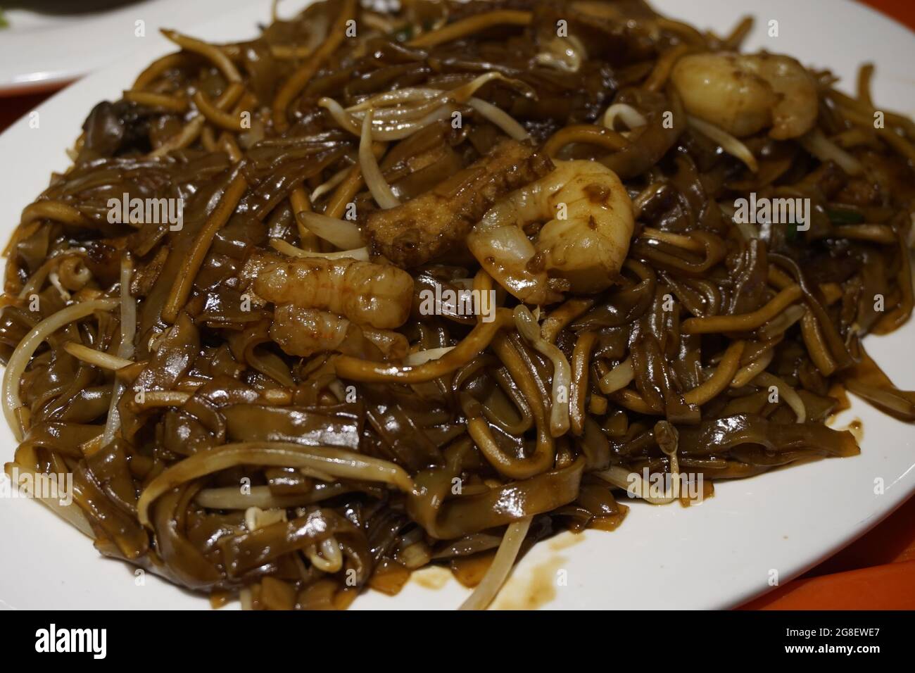 Char Kway Teow ist ein chinesisch inspiriertes Reisnudel-Gericht aus Südostasien, das mit einem Rührbraten zubereitet wird. Stockfoto