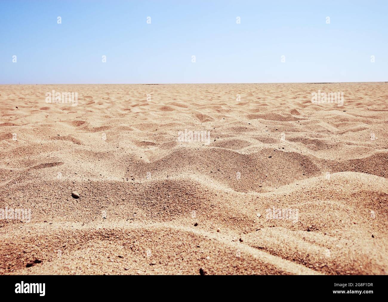 Sand vor blauem Himmel Hintergrund Stockfoto