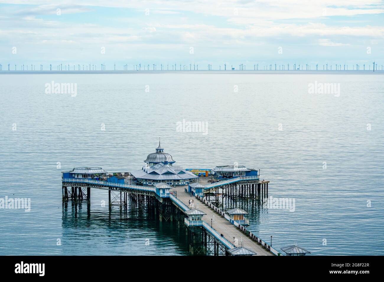 LLANDUDNO, WALES - 04. JULI 2021: Blick auf den Llandudno Pier und einen 576-Megawatt-Windpark Gwynt-y-Mor. Stockfoto