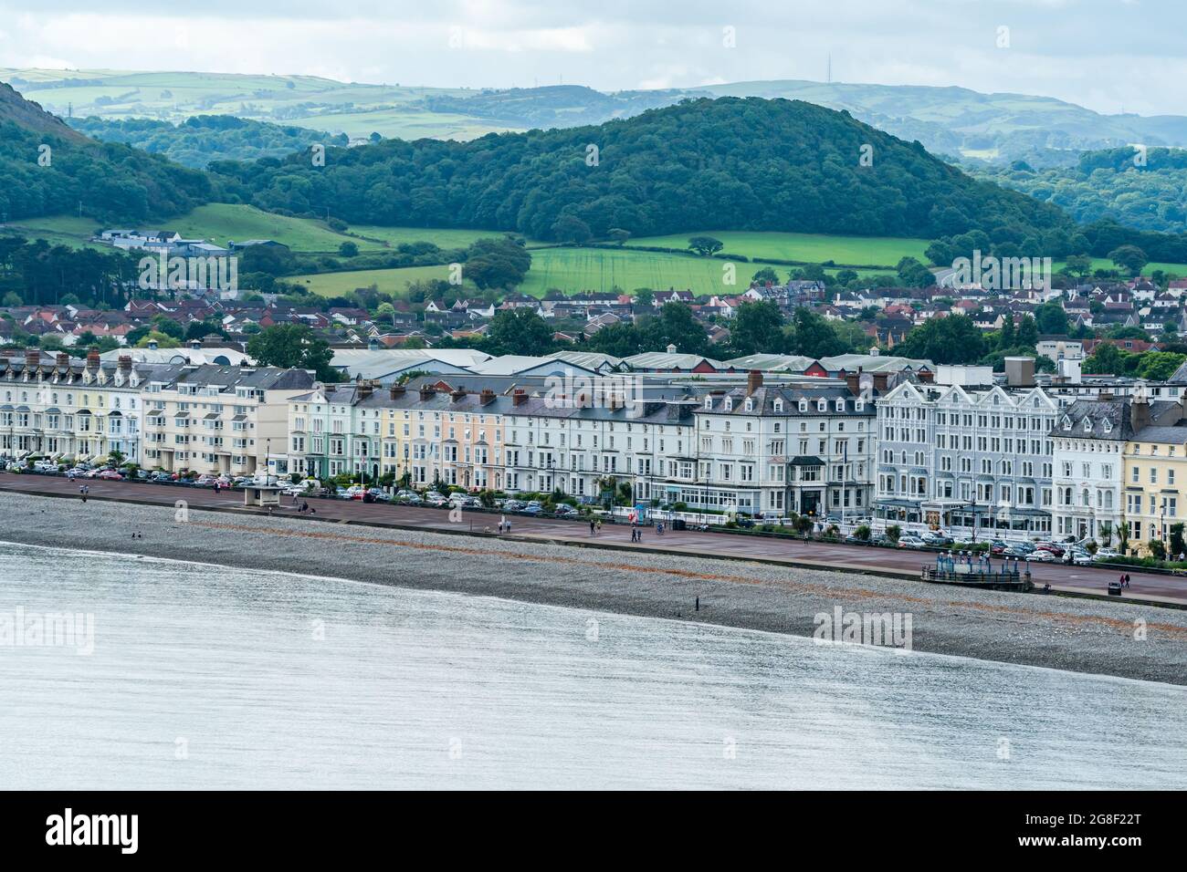 LLANDUDNO, WALES - 04. JULI 2021: Blick auf die kurvige Promenade von Llandudno, gesäumt von Hotels. Stockfoto