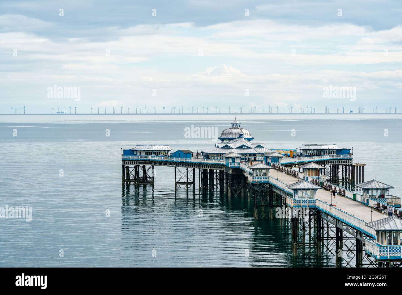 LLANDUDNO, WALES - 04. JULI 2021: Blick auf den Llandudno Pier und einen 576-Megawatt-Windpark Gwynt-y-Mor. Stockfoto