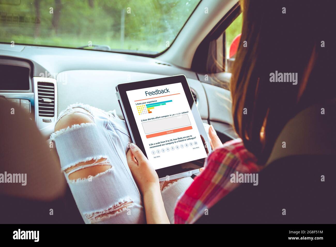 Frau schreibt eine Kundenbewertung und hinterlässt eine Bewertung auf dem Tablet. Kundenerfahrung und Feedback-Konzept. Stockfoto