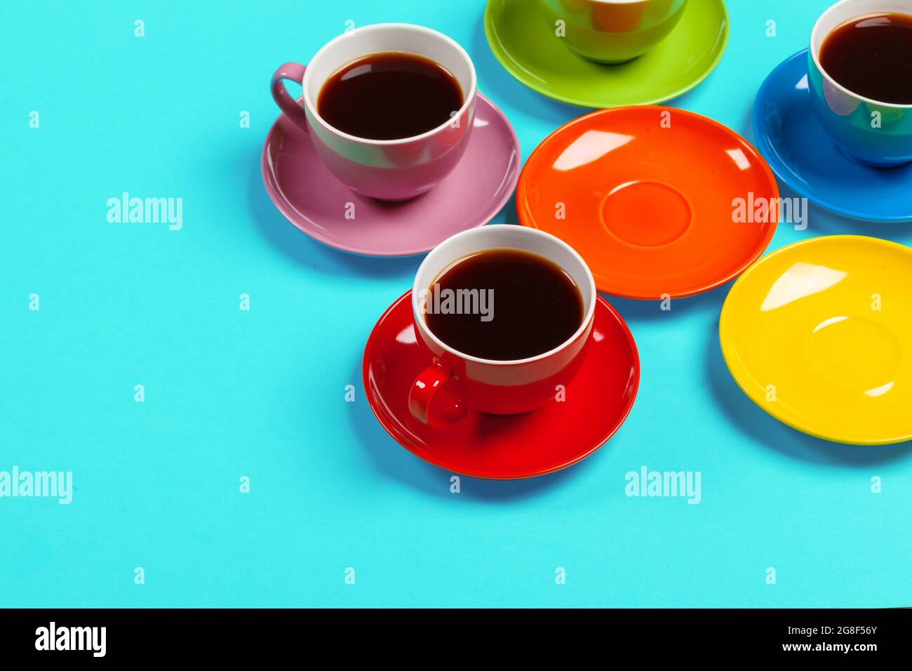 Bunte Kaffeetassen und Untertasse auf farbenfrohem Hintergrund  Stockfotografie - Alamy