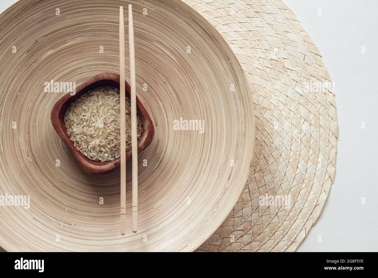 Parboiled Reis in Holzschüssel mit Holzstäbchen Stockfoto