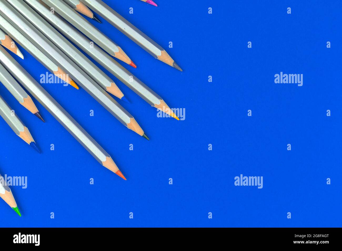 Farbstifte auf dem Tisch. Zeichenset auf blauem Büroschreibtischset. Blauer Hintergrund und Draufsicht Stockfoto