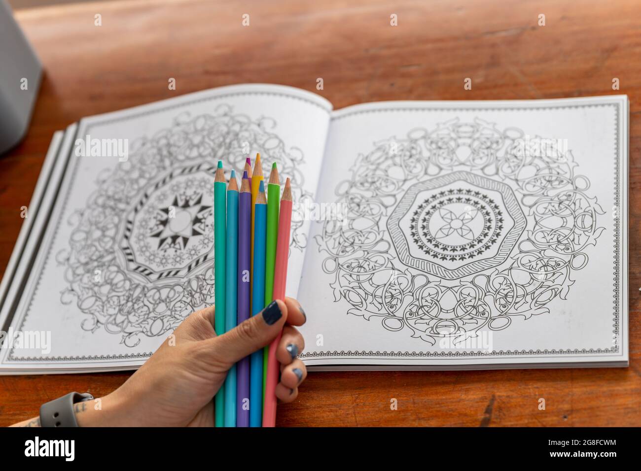 Eine Handvoll Buntstifte und ein Buch Mandalas zum Färben Stockfoto