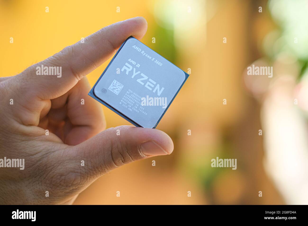 Halten Sie eine AMD ryzen 3600 Desktop-pc-cpu, einen Computerkomponenten-Chip, in der Hand Stockfoto