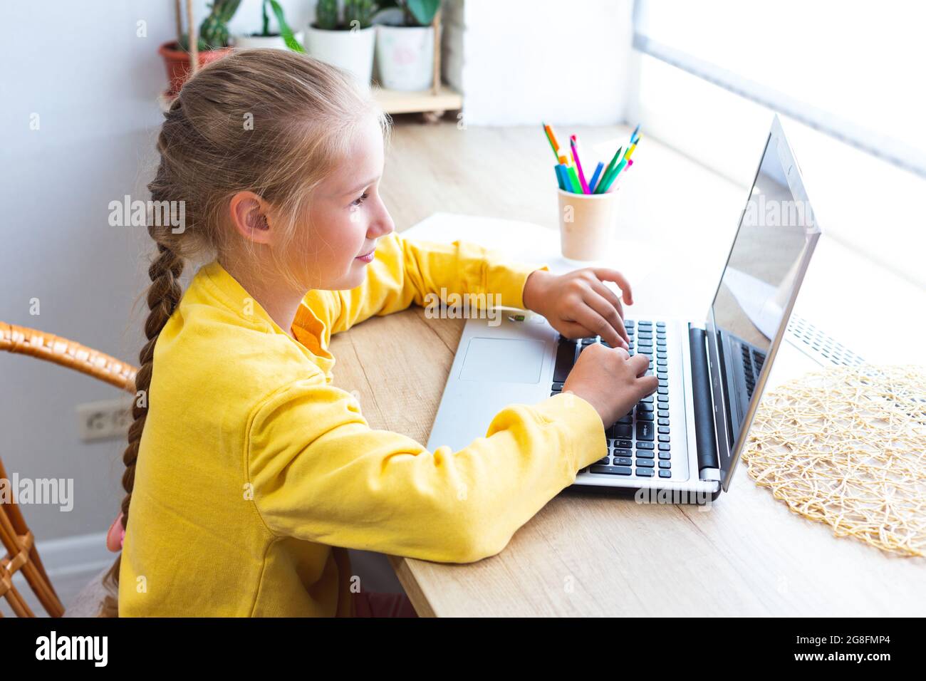 Kaukasisch blonde Schulmädchen, tippen auf einer Laptop-Tastatur, Hausaufgaben machen, bloggen, chatten, Social-Media-Seiten ansehen oder spielen. E-Learning, zurück Stockfoto