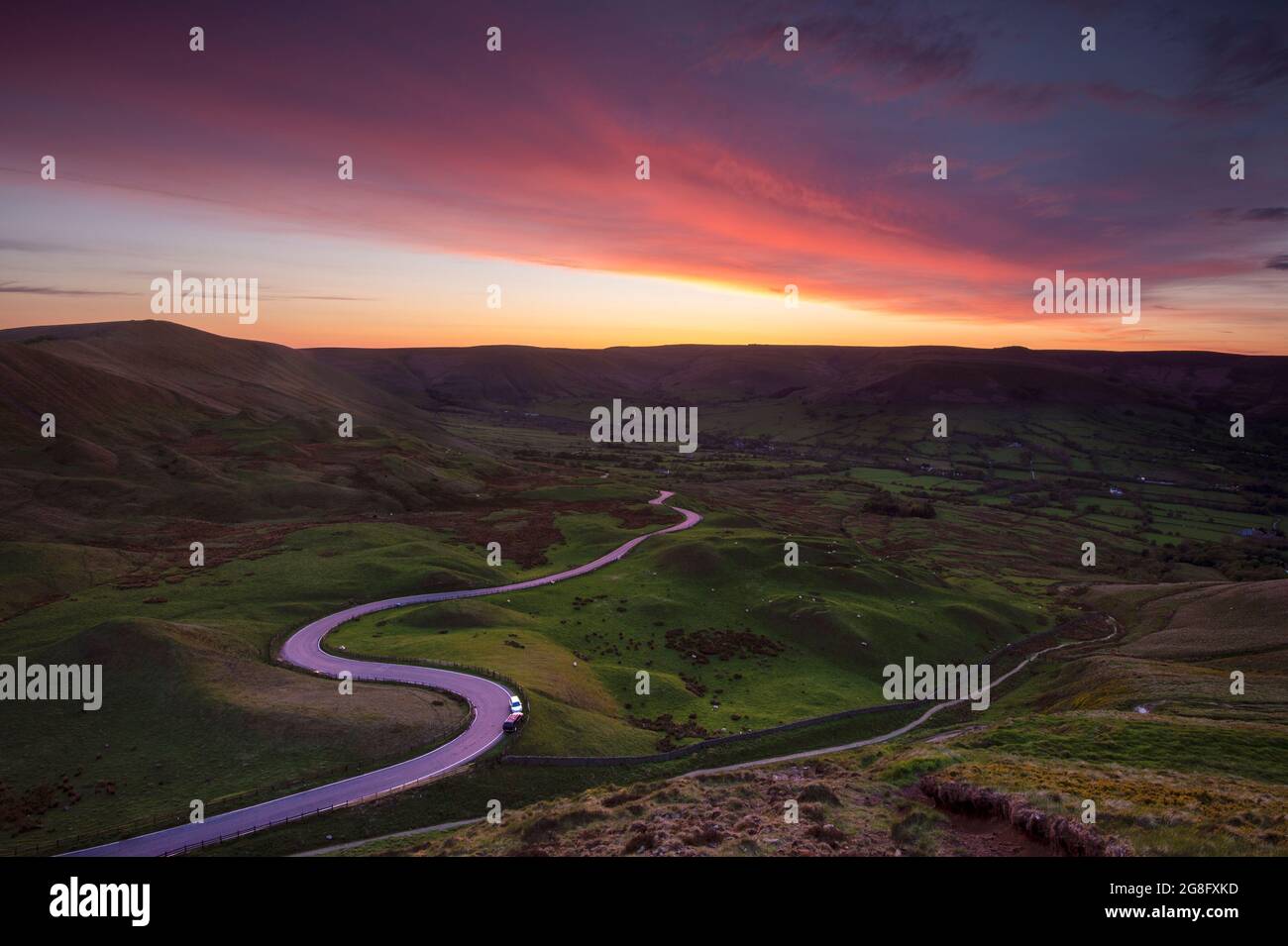 Spektakulärer Sonnenuntergang am Rushup Edge mit einer kurvenreichen Straße nach Edale, Peak District, Derbyshire, England, Großbritannien, Europa Stockfoto