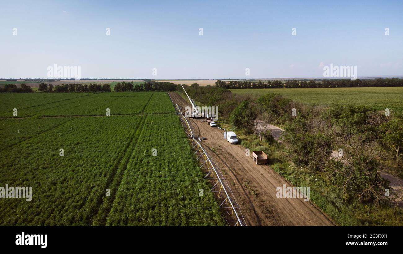 Installation eines Bewässerungssystems in einem Kartoffelfeld. DJI Mavic Mini 2 Drohnenfotografie Stockfoto