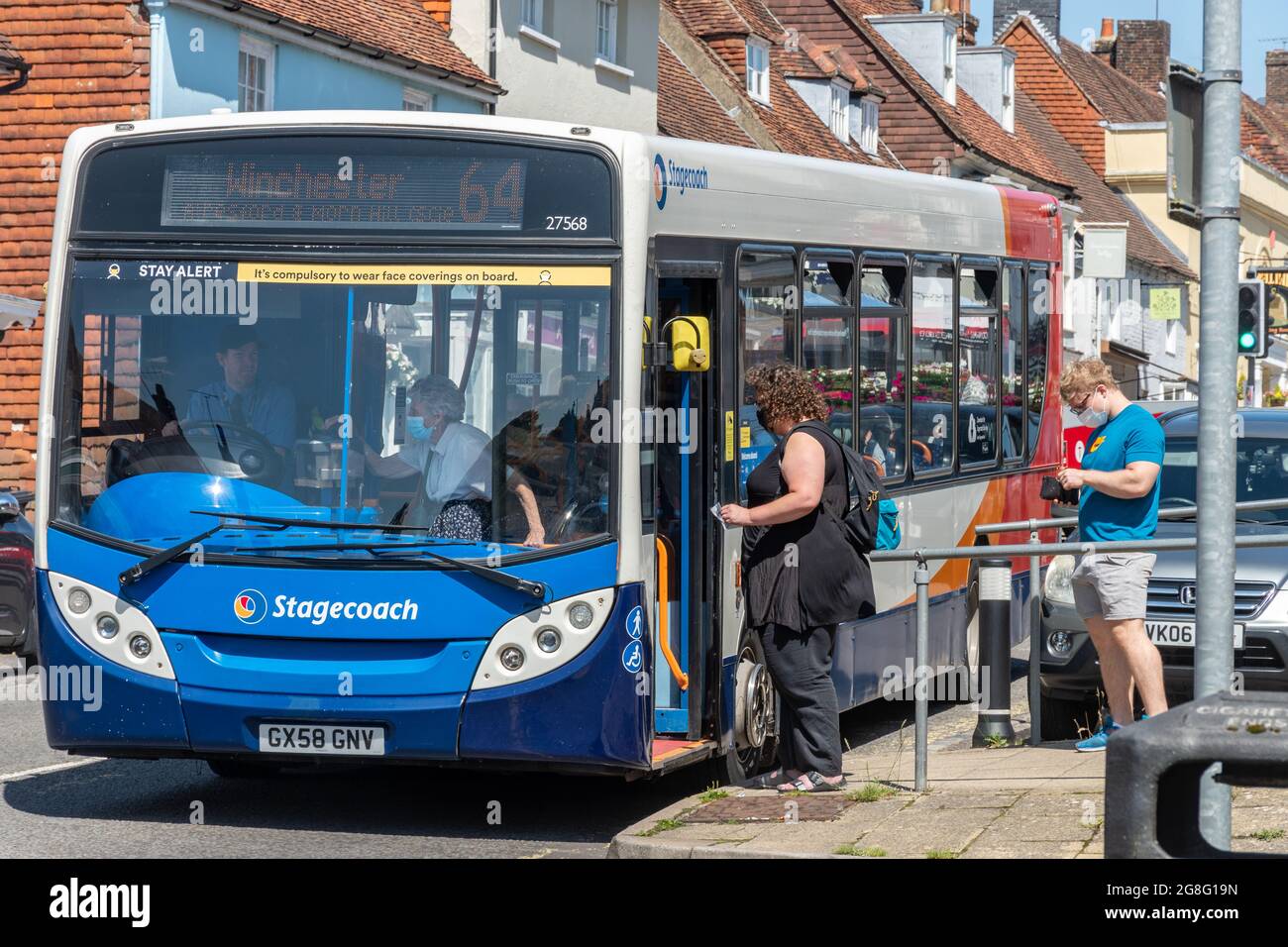 Menschen mit Gesichtsmasken besteigen einen Bus in Hampshire, Großbritannien, während der Coronavirus-Pandemie Covid-19 Stockfoto