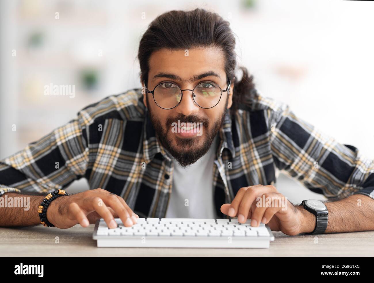 Junger Mann aus dem Nahen Osten, Programmierer, der am Arbeitstisch sitzt Stockfoto