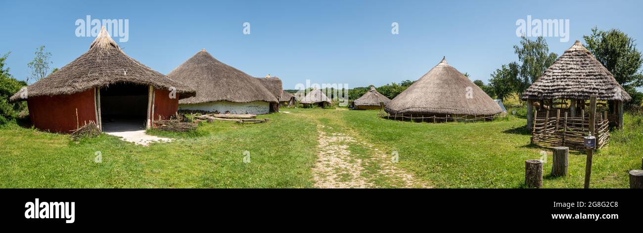 Rundhäuser und Siedlungen aus der Eiszeit wurden im archäologischen Freilichtmuseum Butser Ancient Farm in Hampshire, England, Großbritannien, rekonstruiert. Panoramablick. Stockfoto