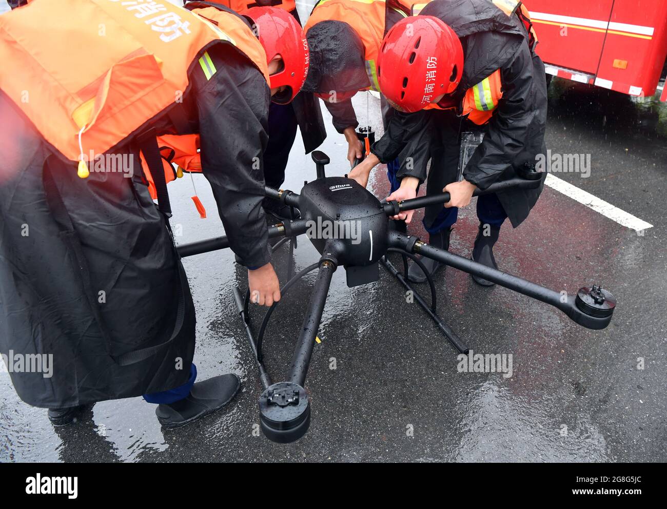 Jiaozuo, Chinas Provinz Henan. Juli 2021. Feuerwehrleute bedienen eine Drohne, um die Hochwasserkontrolle in der Gemeinde Zhouzhuang, Bezirk Xiuwu in Jiaozuo, Provinz Henan, in Zentralchina, durchzuführen, 20. Juli 2021. Die Flüsse in Jiaozuo haben einen Anstieg des Wasserpegels erlebt, als in letzter Zeit andauernde Regenfälle die Stadt heimgesucht haben. Die lokalen Behörden haben Hochwasserschutzkräfte organisiert, um die Stadt rund um die Uhr zu patrouillieren und versteckte Gefahren zu beseitigen, um die Sicherheit von Leben und Eigentum der Menschen zu schützen. Quelle: Li Jianan/Xinhua/Alamy Live News Stockfoto