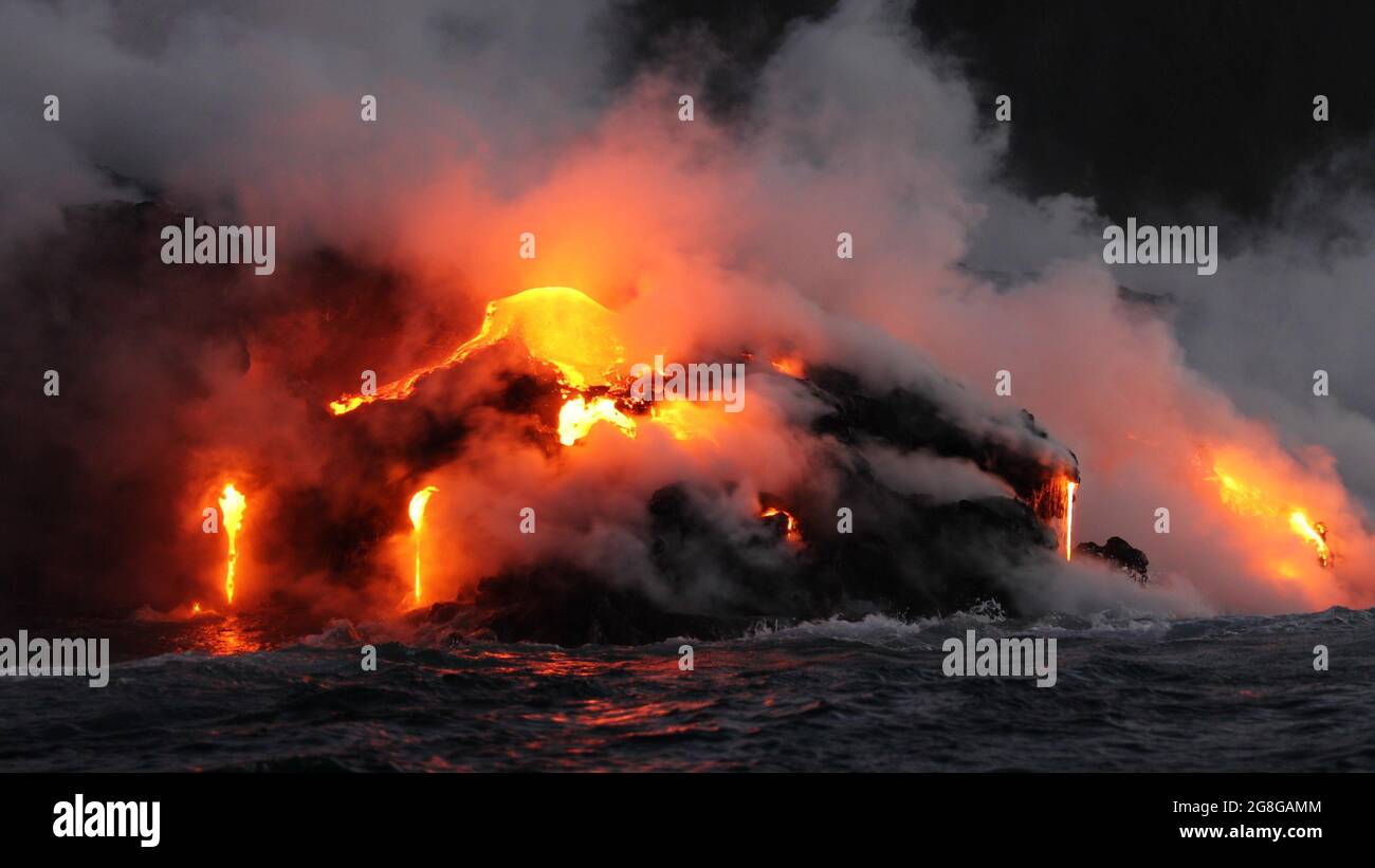 Lava, die durch den Vulkanausbruch auf Big Island Hawaii im Ozean fließt. Von der Lava-Bootstour aus gesehen. Lava aus dem Vulkan Kilauea von Hawaii Vulkanen Stockfoto