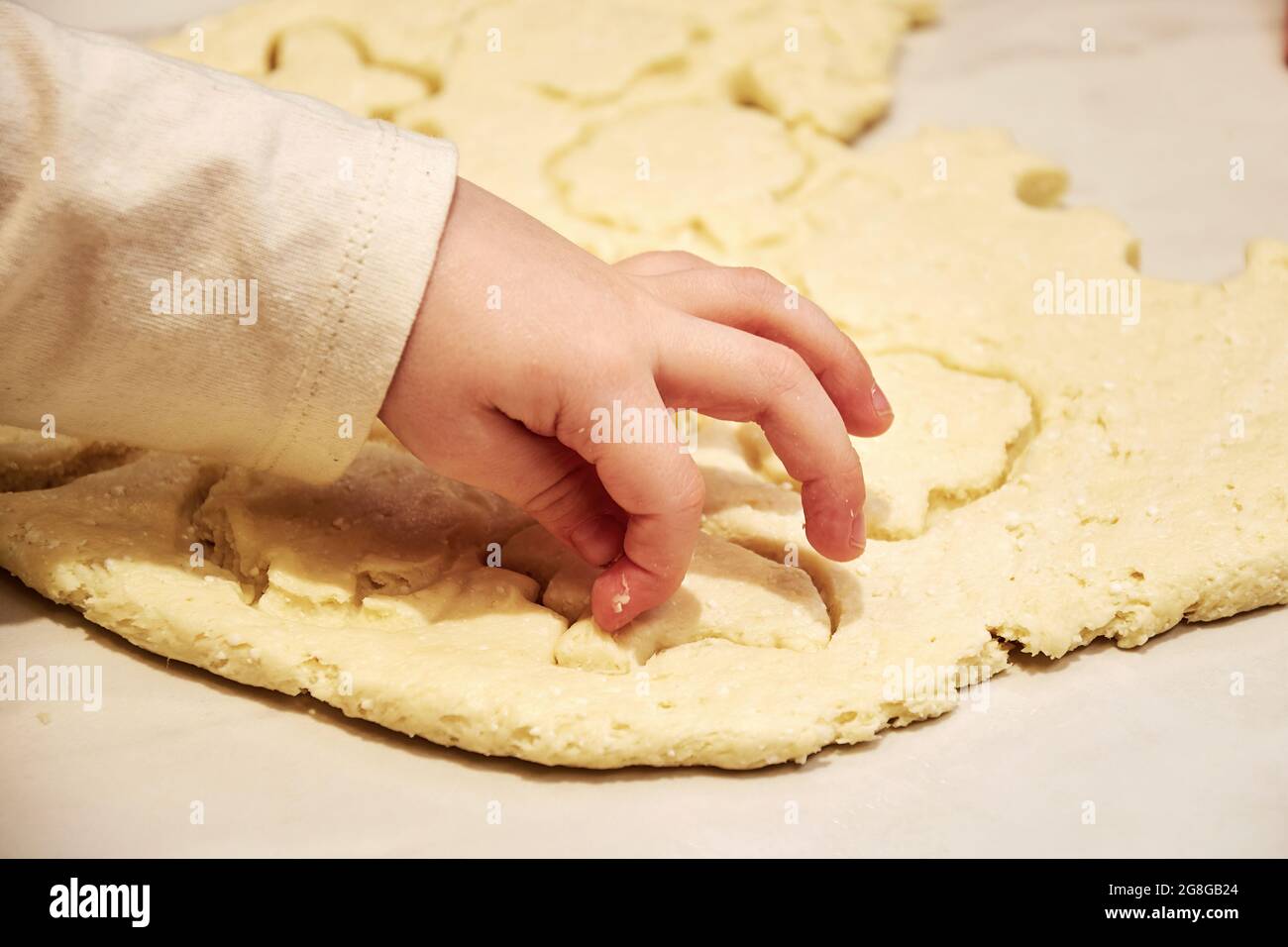 Familie mit einem jungen Kind, das zusammen süße Kekse in der Küche kocht. Familientraditionen und Spaß haben Stockfoto