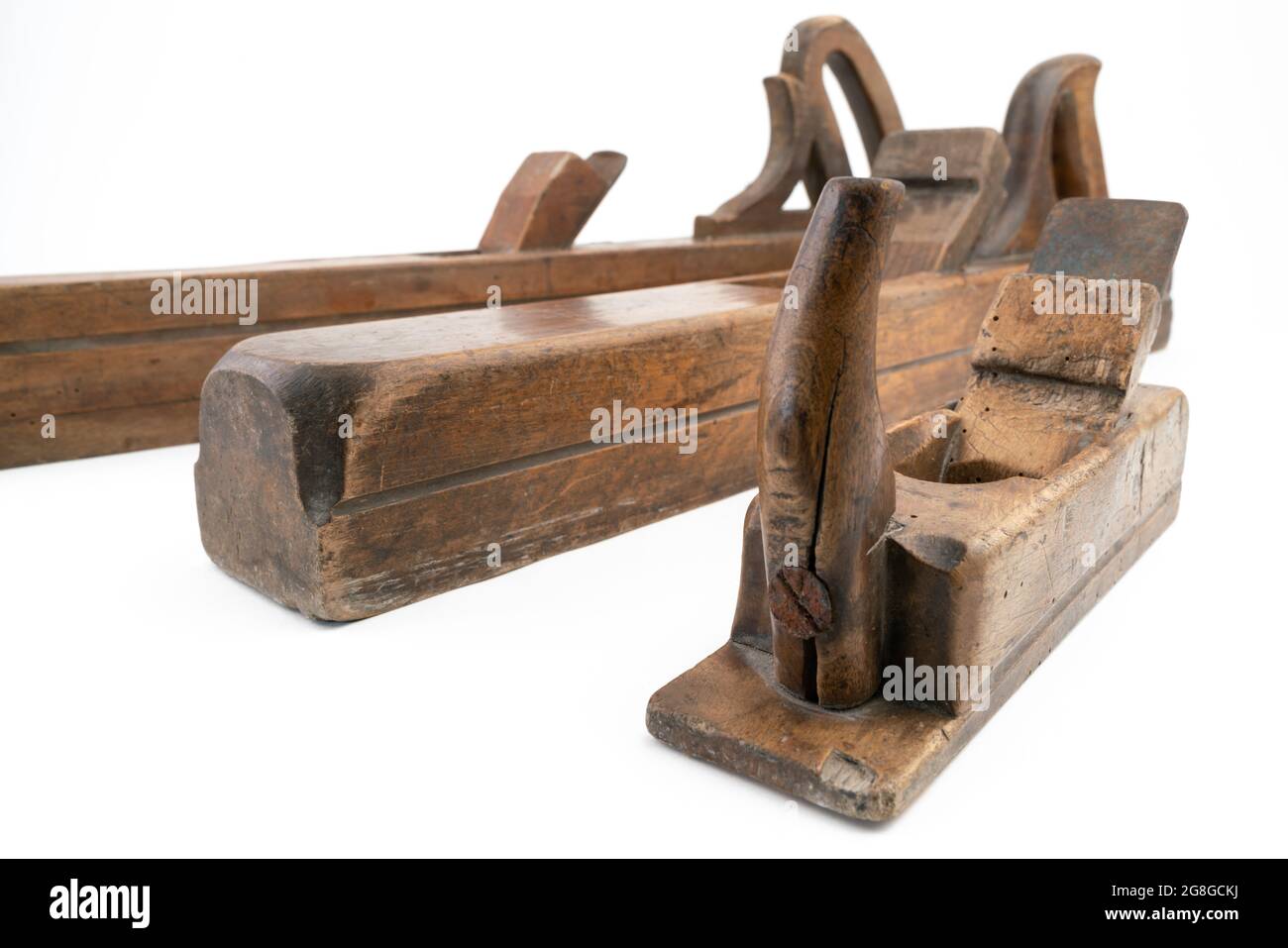 High-Angle-Studio-Aufnahme von drei Vintage-Holzhobelmaschinen in verschiedenen Größen, isoliert auf weißem Hintergrund. Alte Tischlerwerkzeuge mit Holzwurmlöchern Stockfoto