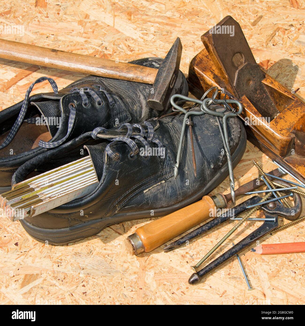 Verschiedene Tischlerwerkzeuge und Arbeitsschuhe Stockfoto
