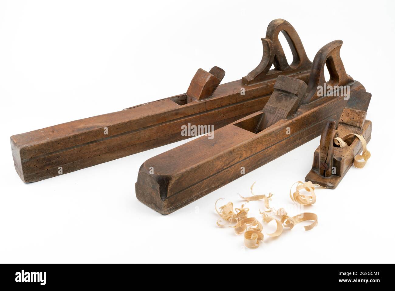 High-Angle-Studio-Aufnahme von drei Vintage-Holzhobelmaschinen in verschiedenen Größen, isoliert auf weißem Hintergrund. Alte Tischlerwerkzeuge mit Holzwurmlöchern. Dünn Stockfoto