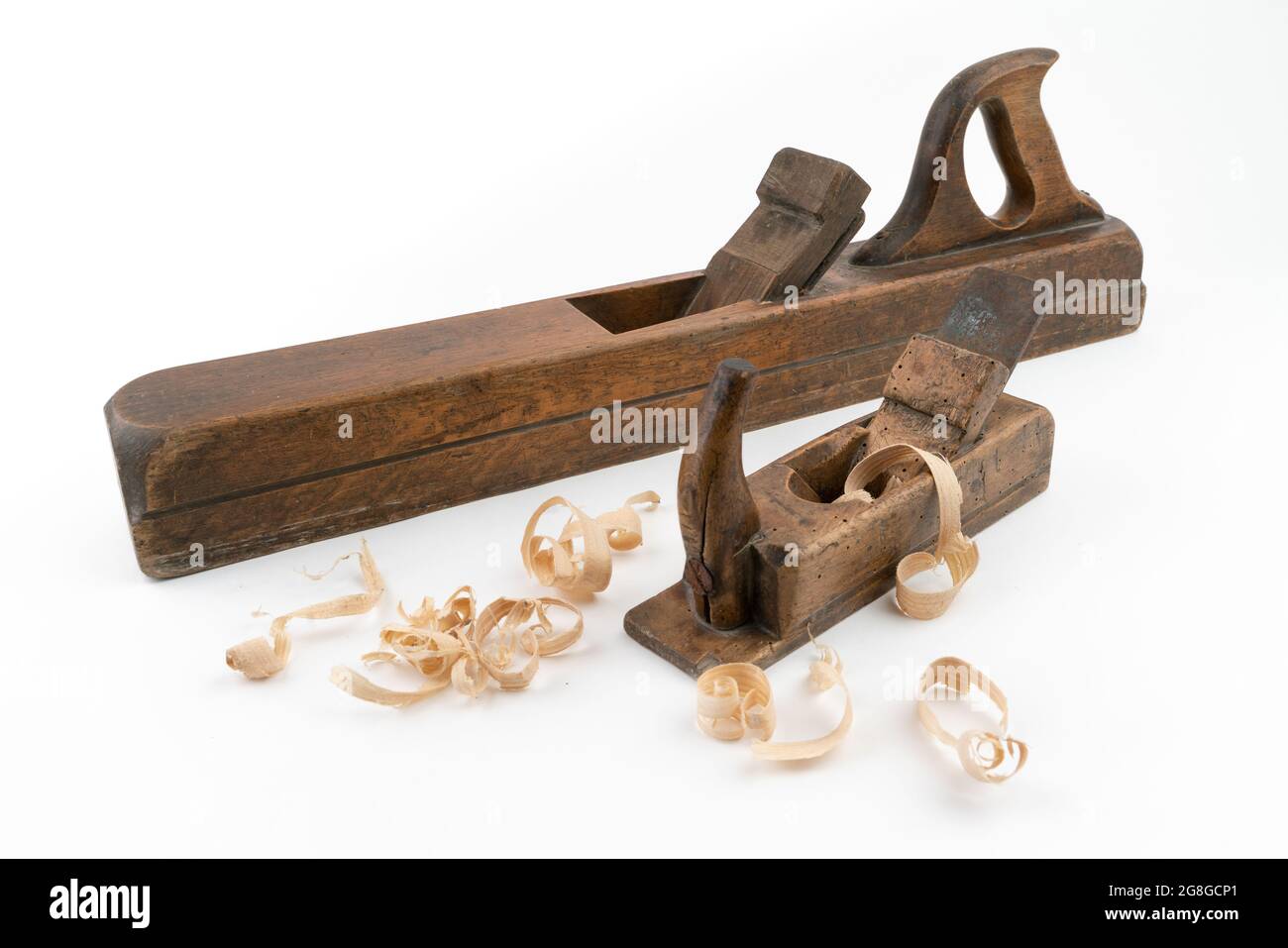 High-Angle-Studio-Aufnahme von zwei Vintage-Holzhobelmaschinen in verschiedenen Größen, isoliert auf weißem Hintergrund. Alte Tischlerwerkzeuge mit Holzwurmlöchern. Dünn Stockfoto