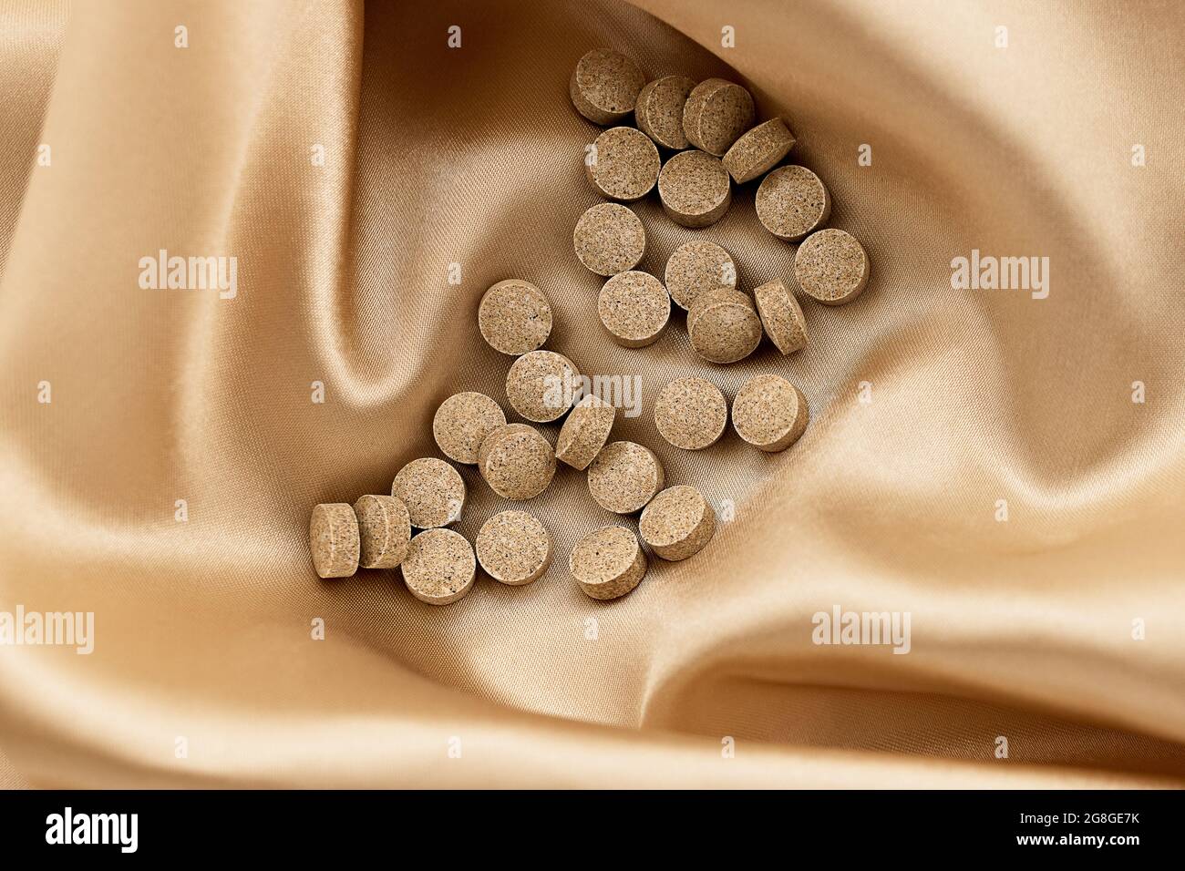 Papaya Enzyme Kautabletten auf Seidenhintergrund. Geistiges Wohlbefinden und persönliches Gesundheitskonzept Stockfoto