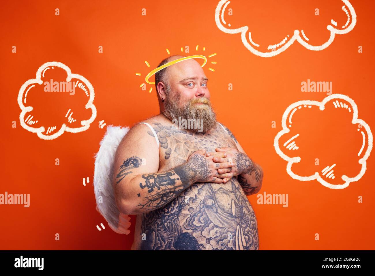 Ein fetter Mann mit Bart, Tattoos und Flügeln wirkt wie ein Engel Stockfoto