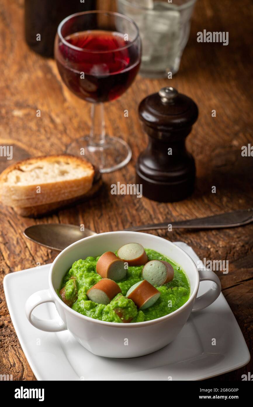 Cremige Erbsensuppe auf dunklem Holz Stockfoto