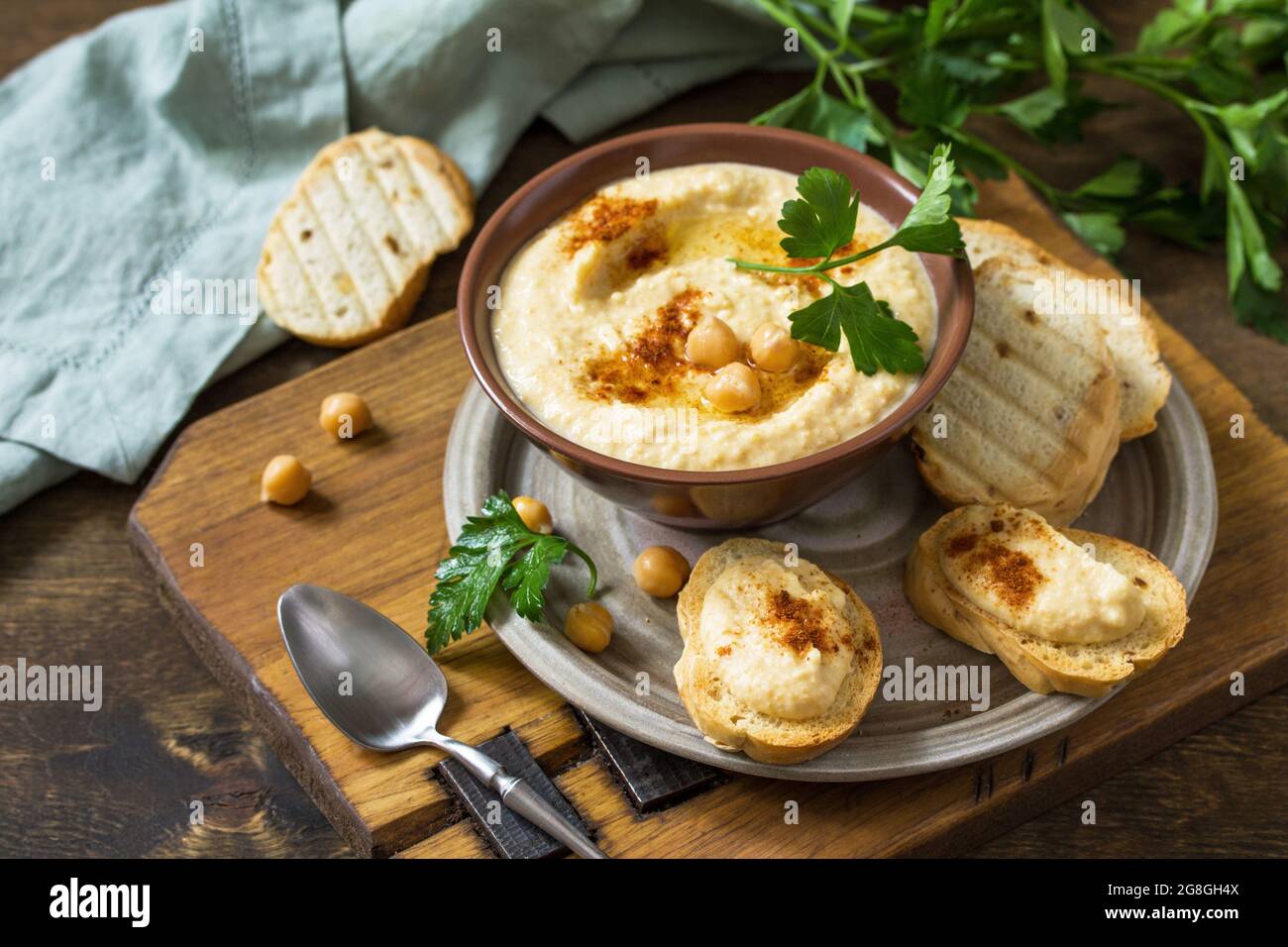 Nahöstliche, Hummus-Arabische Küche. Vegetarische Dips hausgemachter Kichererbsen-Hummus mit Olivenöl, Paprika auf einem rustikalen Tisch. Stockfoto