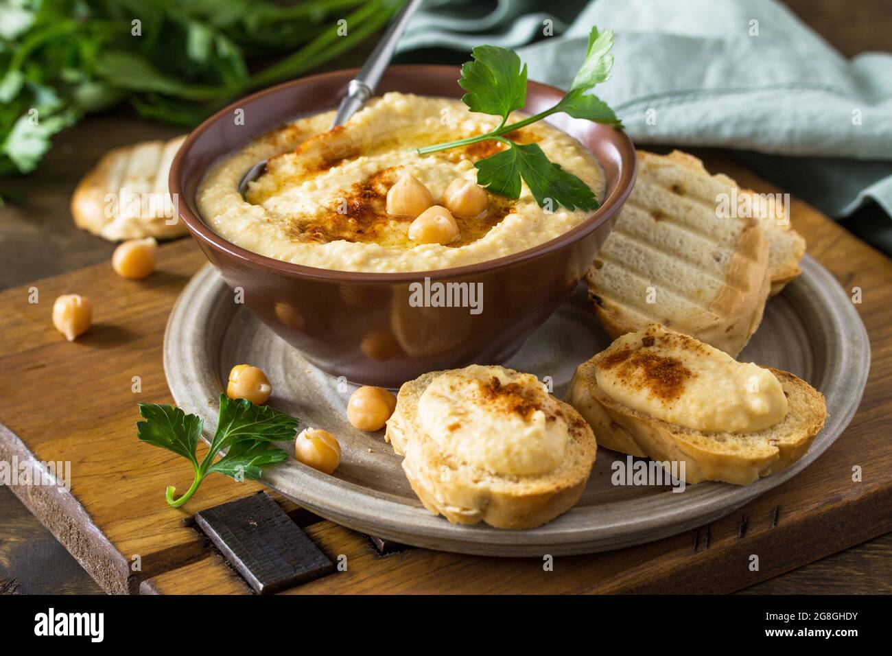 Nahöstliche, Hummus-Arabische Küche. Vegetarische Dips hausgemachter Kichererbsen-Hummus mit Olivenöl, Paprika auf einem rustikalen Tisch. Stockfoto