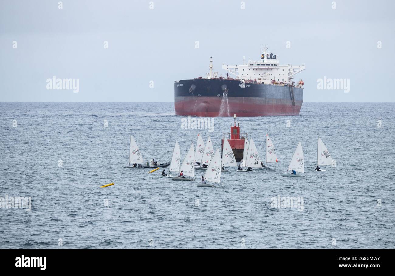 Kleines Segelschiff in der Nähe von Bohrschiffen. Stockfoto