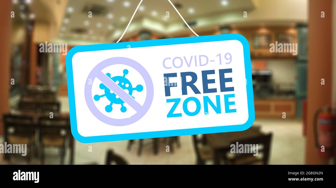 Covid Freizone Zeichen. COVID 19 FREE ZONE Text Label hängend, Blur Café Restaurant Hintergrund. Desinfizierte Bereiche, nur geimpftes Konzept Stockfoto
