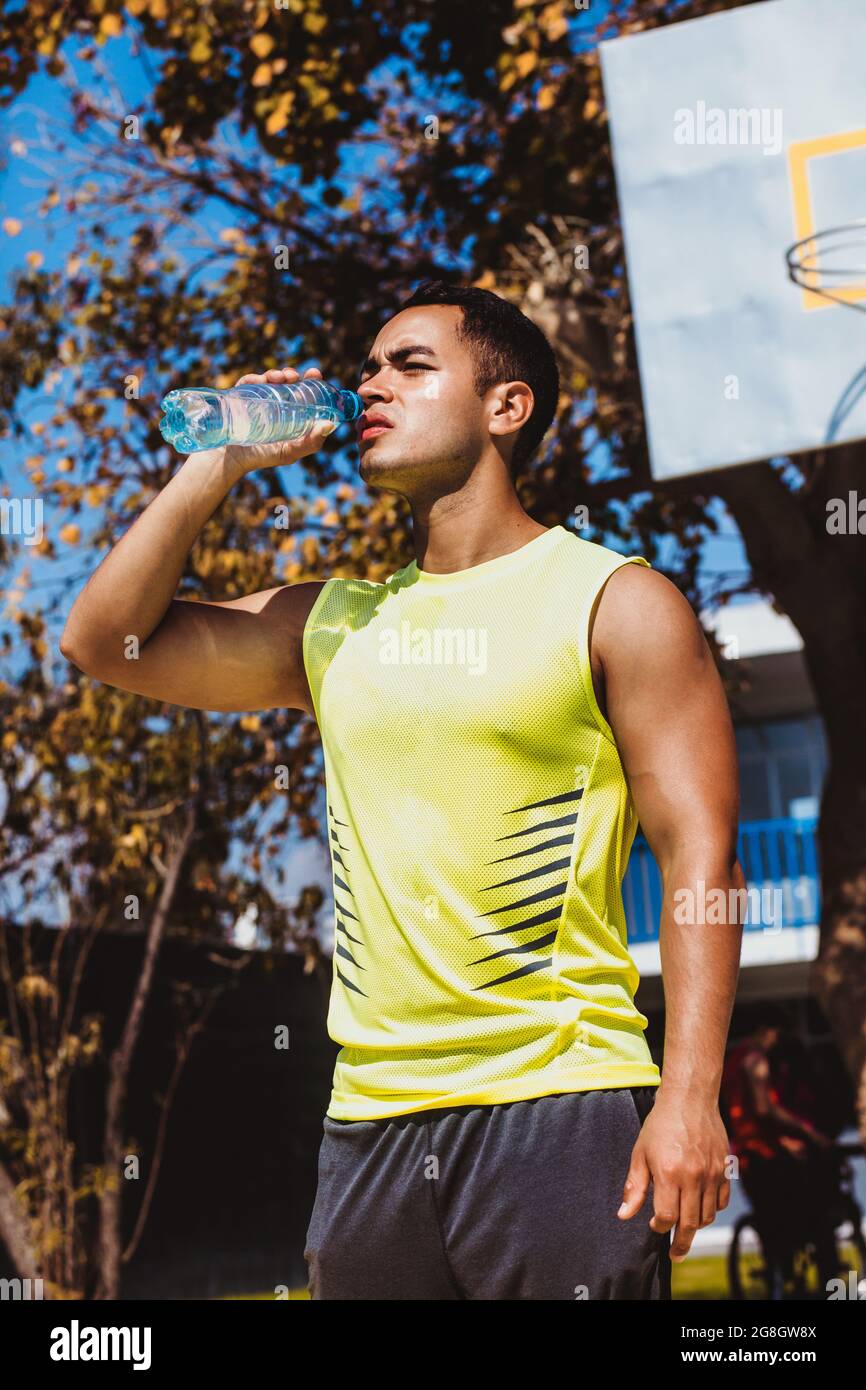 Porträt eines jungen lateinamerikaners, der nach seiner Ausbildung in Mexiko, Lateinamerika, eine Flasche Wasser trinkt Stockfoto