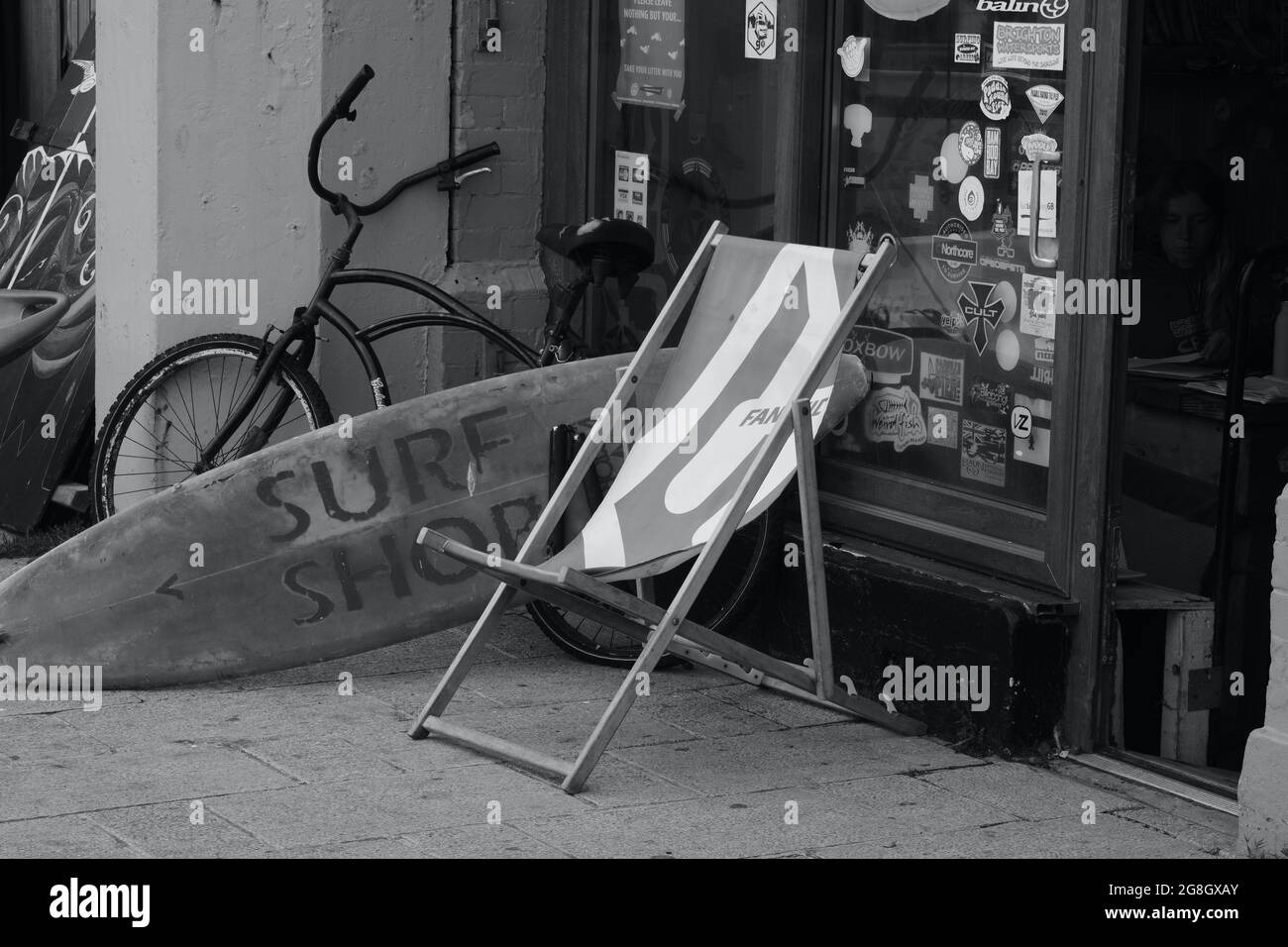 Brighton, East Sussex, England. Juli 05 2021 EIN monochromes Bild eines  Vintage-Strandladens mit Liegestuhl, Surfbrett und Fahrrad draußen  Stockfotografie - Alamy
