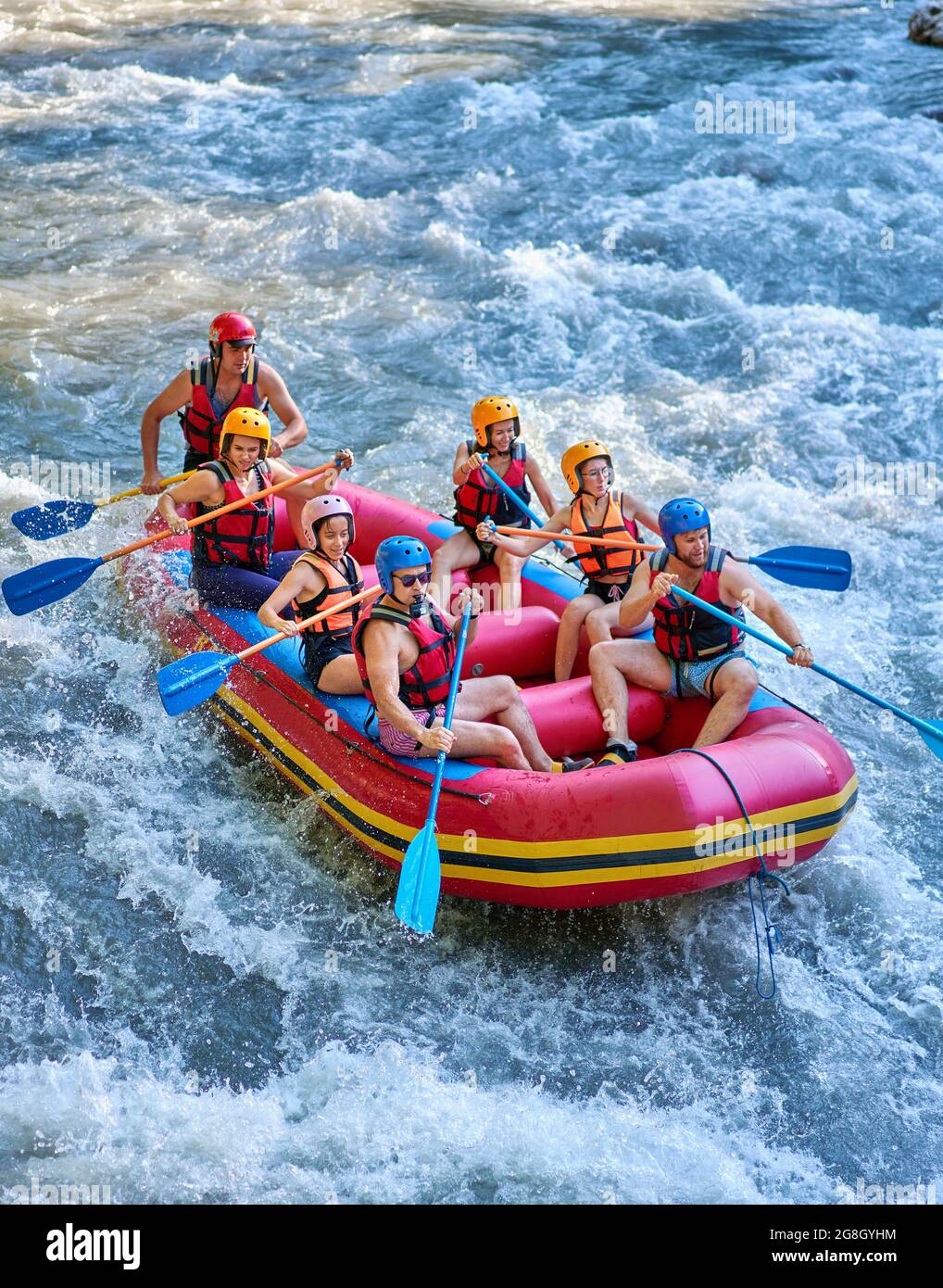 Gruppe von Touristen, die mit dem starken Strom des Gebirgsflusses kämpfen. Stockfoto