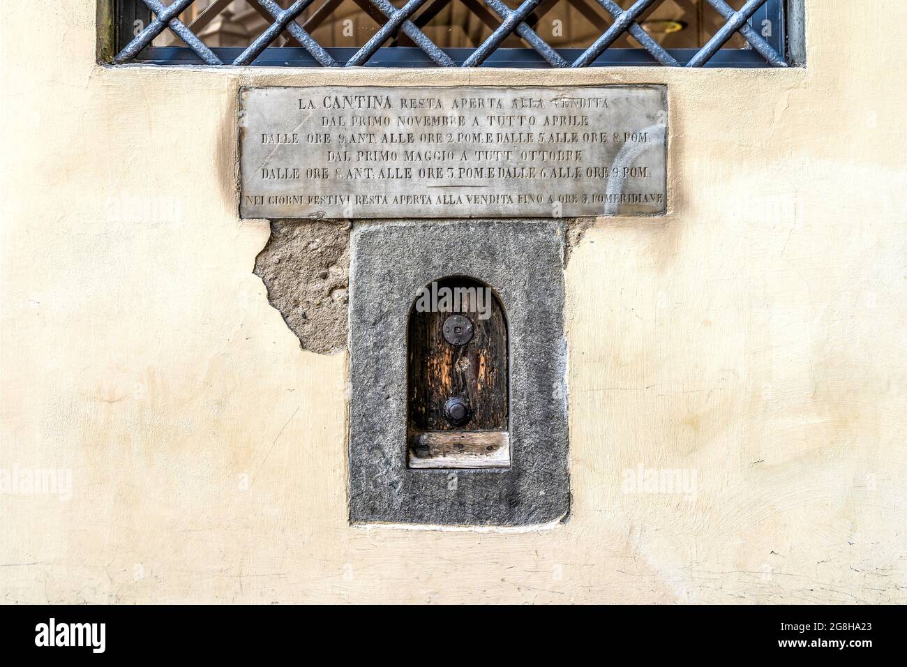 Weinfenster oder 'Buchetta del vino', eingebettet in die Seite eines jahrhundertealten Gebäudes, das in der Vergangenheit zum Verkauf von Wein in Florenz, der Toskana, Italien, genutzt wurde. Stockfoto