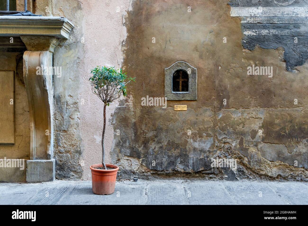 Weinfenster oder 'Buchetta del vino', eingebettet in die Seite eines jahrhundertealten Gebäudes, das in der Vergangenheit zum Verkauf von Wein in Florenz, der Toskana, Italien, genutzt wurde. Stockfoto