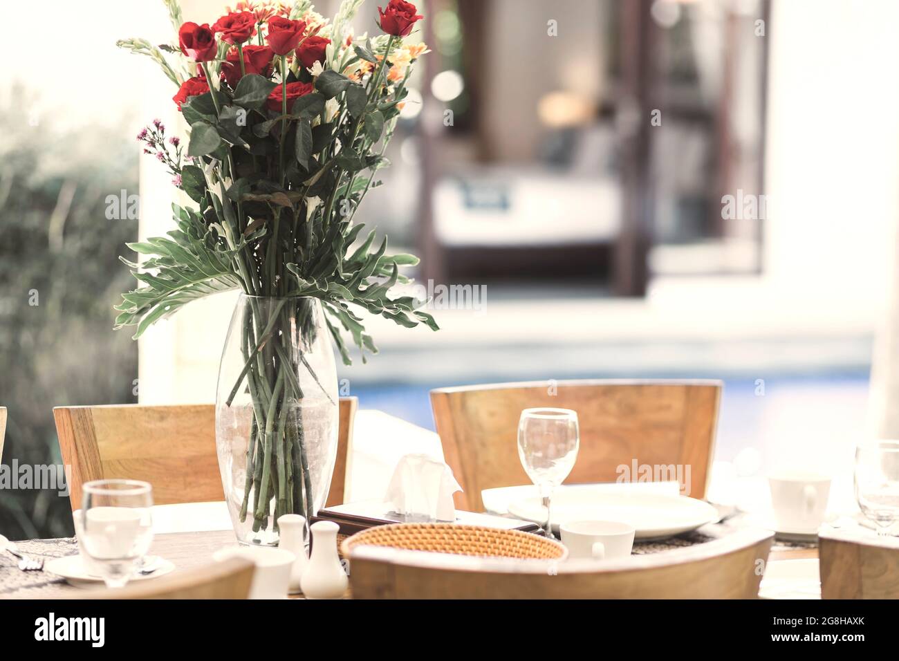 Blumenstrauß am Tisch und Pool im Hintergrund Stockfoto