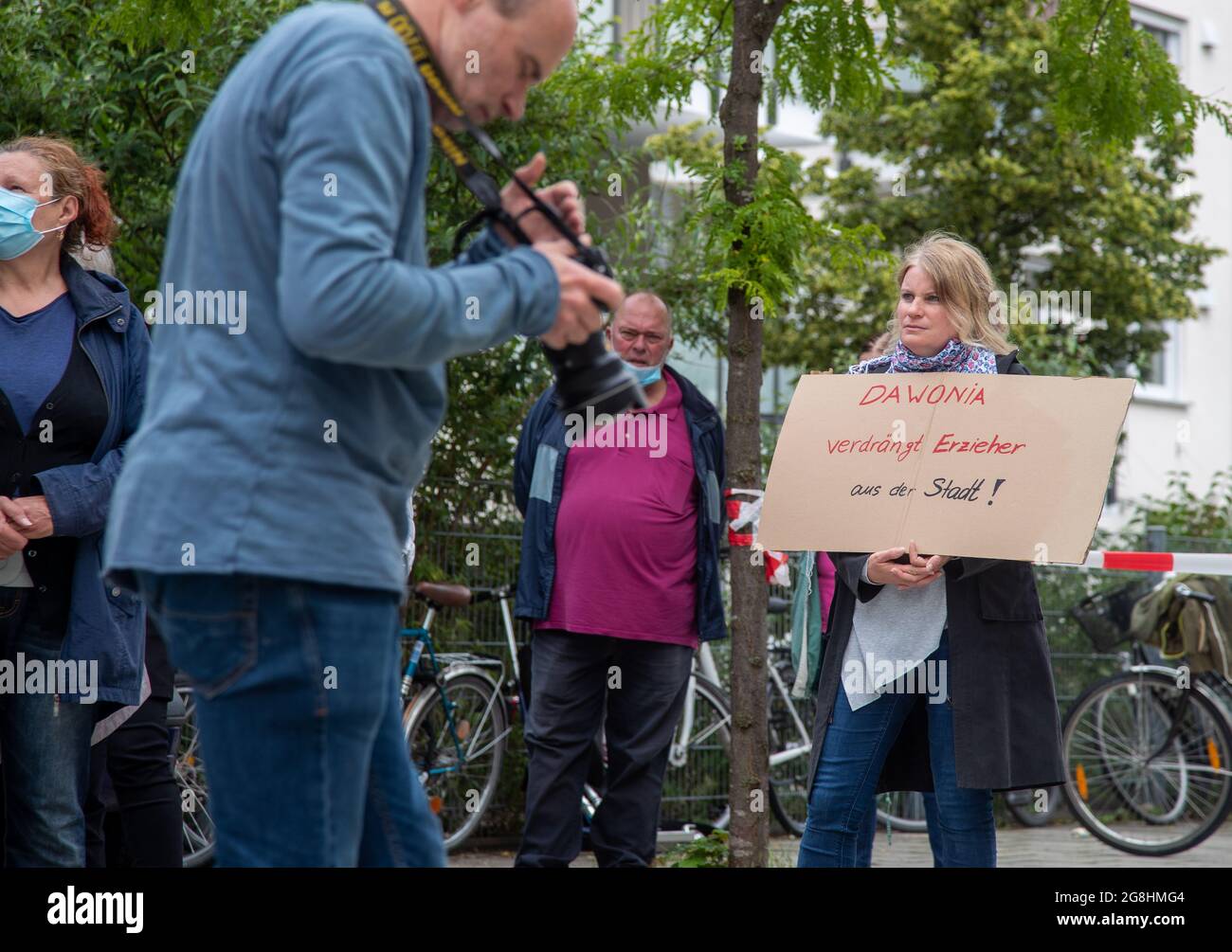 Fotograf Stephan Rumpf steht im Bild und Demonstrantin mit Schild: ' Dawonia verdrängt Erzieher aus der Stadt! Mieterinnen und Mieter der Dawonia ehemals GBW haben sich am 20. Juni zu einem Protest gegen steigende Mieten und Entmietung von Sozialwohnungen und nicht nur Versammelung. IT languages deceivered Betroffene. (Foto: Alexander Pohl/Sipa USA) Quelle: SIPA USA/Alamy Live News Stockfoto