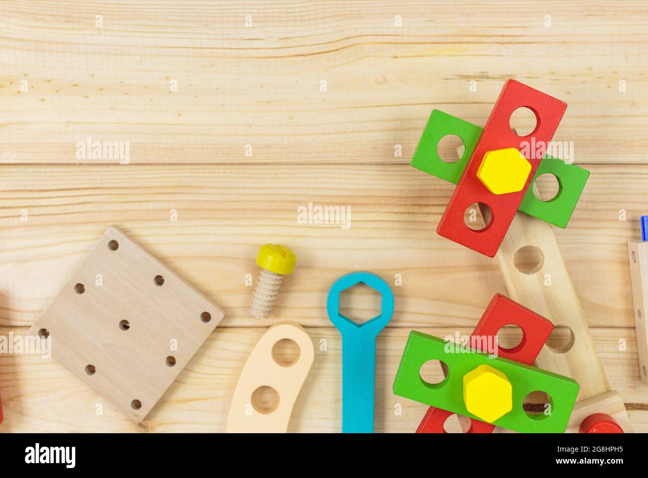 Ein farbenfroher Holzbausatz für Kinder auf Holz. Set von Werkzeugen auf Holztisch. Spiele und Werkzeuge für Kinder in der Vorschule oder Kindertagesstätte. Natürlich, umweltfreundlich Stockfoto