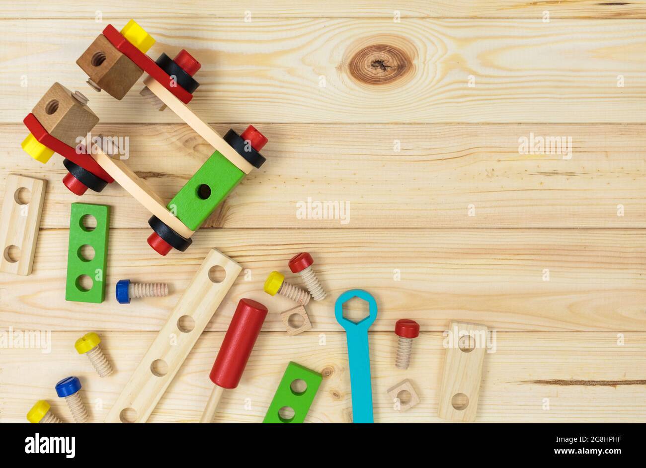 Ein farbenfroher Holzbausatz für Kinder auf Holz. Set von Werkzeugen auf Holztisch. Spiele und Werkzeuge für Kinder in der Vorschule oder Kindertagesstätte. Natürlich, umweltfreundlich Stockfoto