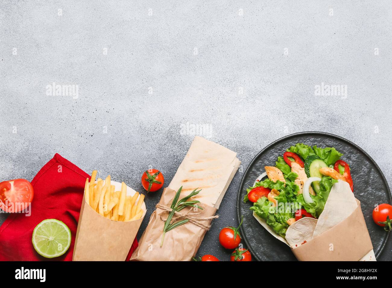 Komposition mit leckeren Döner-Kebabs und pommes auf hellem Hintergrund Stockfoto