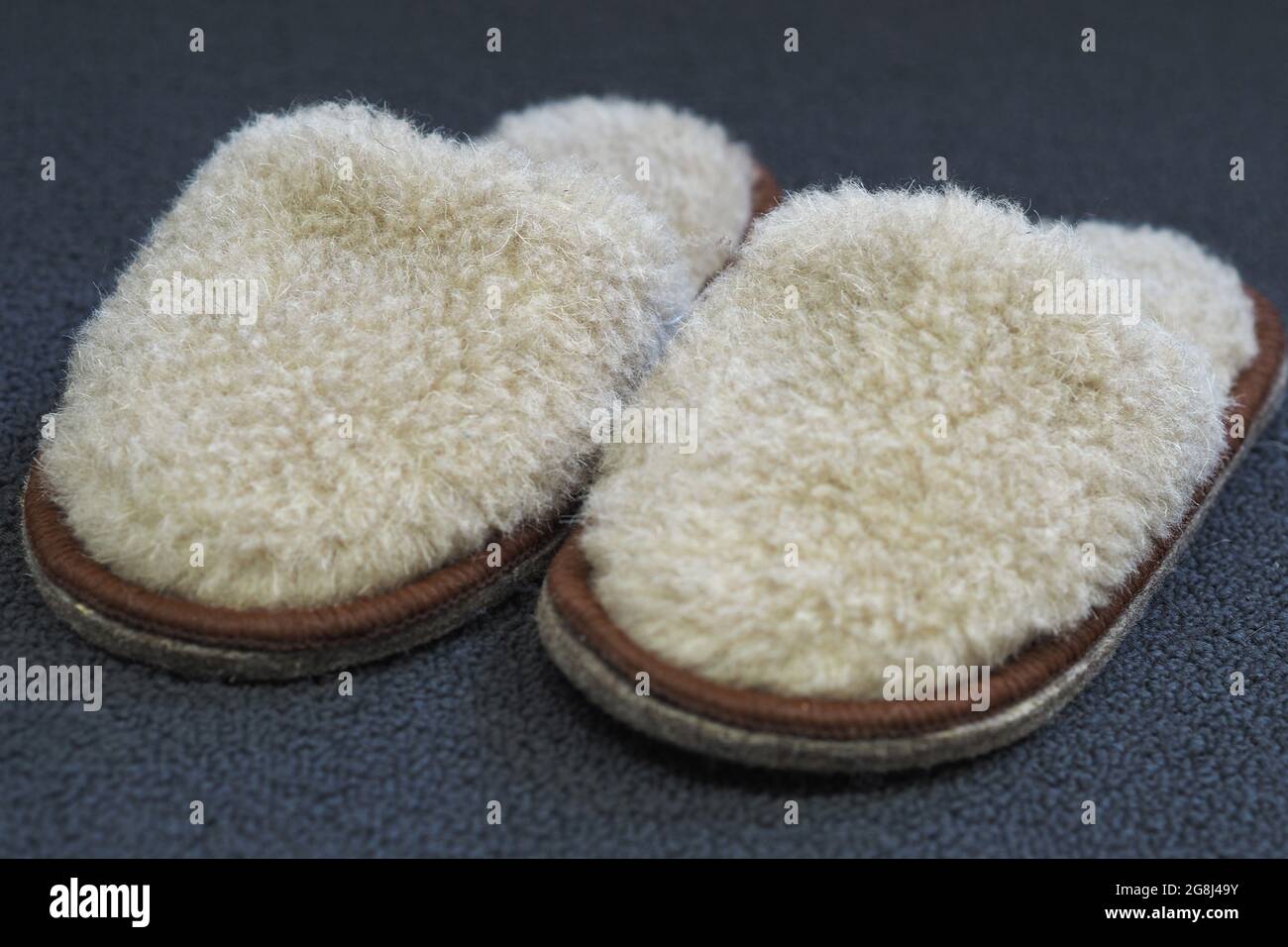 Bequeme Hausschuhe auf einem weichen Teppich. Das Konzept von Komfort, Wärme und Gemütlichkeit. Hochwertige Fotos Stockfoto